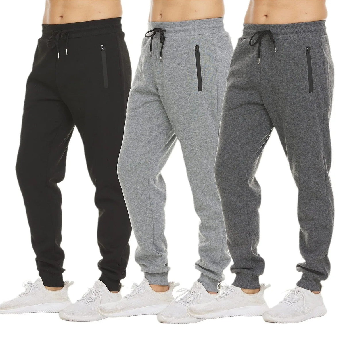 Black, light grey and dark grey jogger sweatpants side by side with white sneakers
