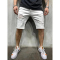 Men's white distressed denim shorts with ripped details, worn with a dark t-shirt and white sneakers