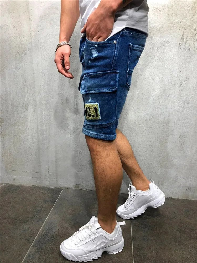 Men's dark blue distressed denim cargo shorts worn from the side, with a thigh pocket and patch detail