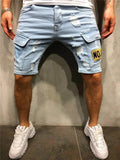 Men's light blue denim cargo shorts with a side pocket, worn with a white t-shirt and white sneakers
