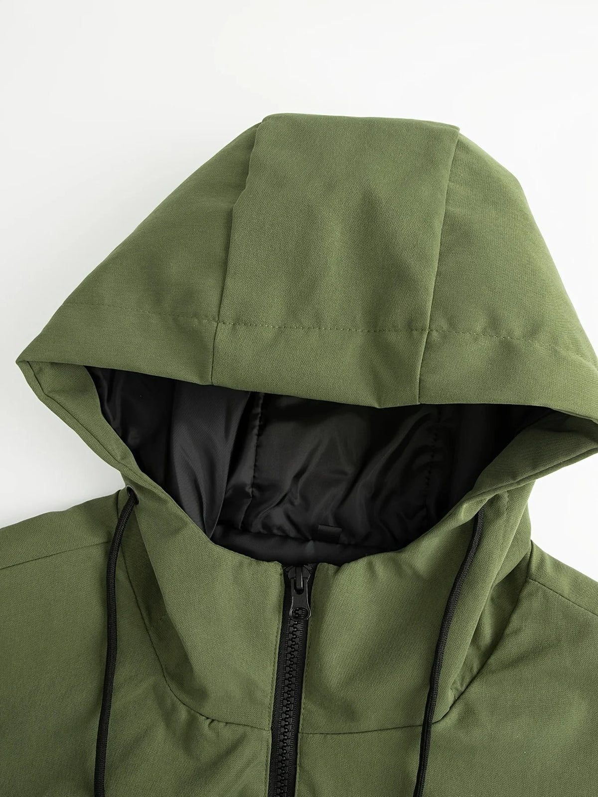 Close-up of a green jacket hood and black zip at the neck