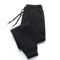 Black jogger sweatpants laid flat with drawstring waist and ribbed ankle cuffs