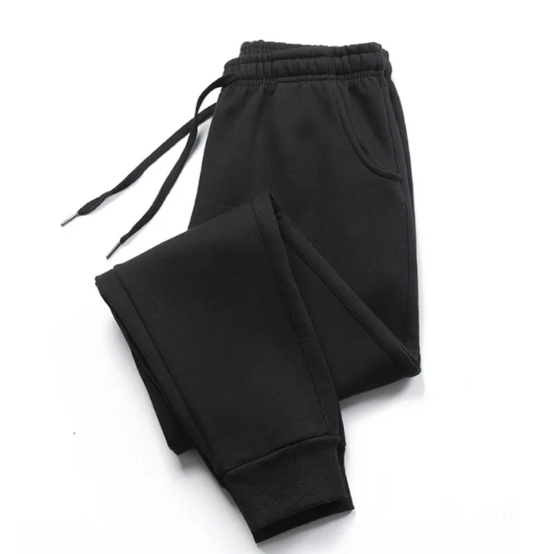 Black jogger sweatpants laid flat with drawstring waist and ribbed ankle cuffs