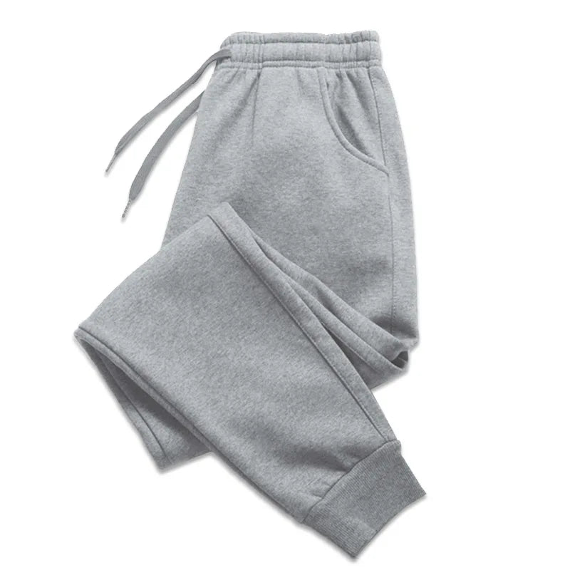 Gray jogger sweatpants laid flat showing the drawstring waist, side pocket and ribbed cuffs