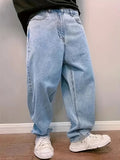 Man wearing light blue washed baggy jeans with white sneakers, three-quarter front view