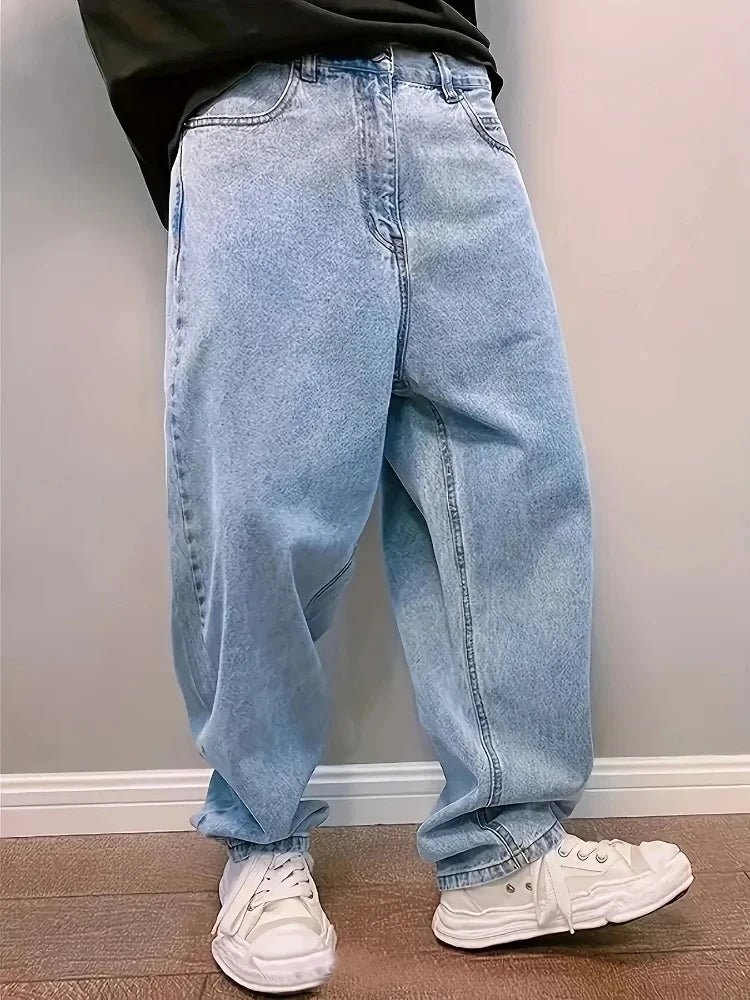 Man wearing light blue washed baggy jeans with white sneakers, three-quarter front view