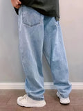 Side view of light blue loose-fit jeans with a faded wash worn with white sneakers