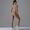 Back view of a woman in a tan short-sleeve top and matching leggings with her hair tied up