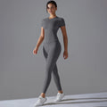 Woman in a grey short-sleeve fitted top and matching full-length leggings, three-quarter view