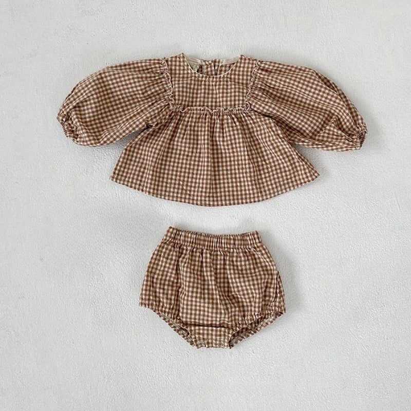 Apricot gingham baby top with puff sleeves and matching bloomers laid flat