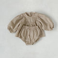 Beige gingham baby top with puff sleeves and matching bloomers laid flat