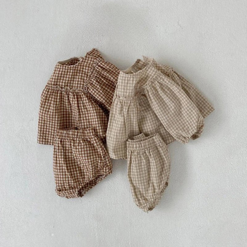 Apricot and beige gingham baby outfits laid flat together