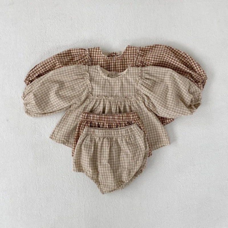 Beige and apricot gingham baby tops with matching bloomers laid flat together