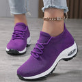 Purple knit slip-on sneakers with laces and a thick white air-cushion sole, worn with an ankle chain