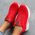 Red knit lace-up sneakers with a thick white sole and square tongue label, seen from above