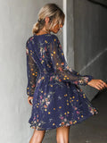 Back and side view of a navy floral mini dress with sheer long sleeves worn with hair up