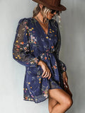 Navy mini dress with small flower print, V-neckline and sheer cuffed sleeves, worn with a brown hat