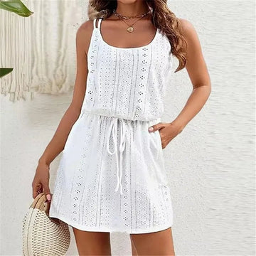 Woman in a white sleeveless scoop-neck mini dress with an eyelet pattern and a drawstring waist holding a woven bag