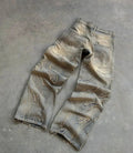 Tan washed baggy wide-leg jeans with frayed thread-line texture and a raw hem